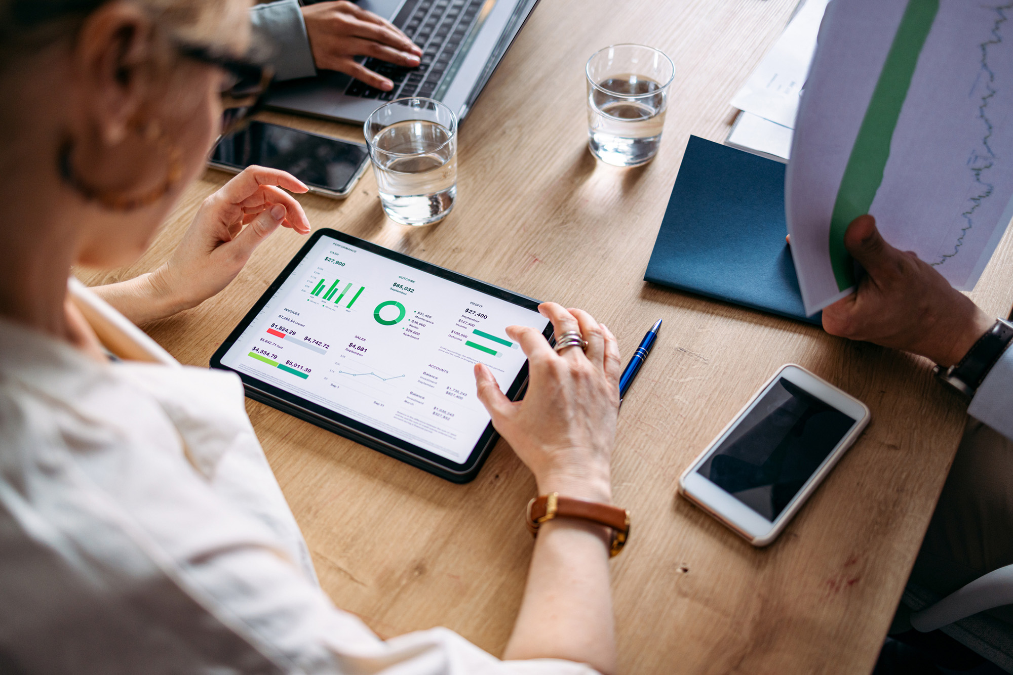 Publisher reviewing CTV ad monetization performance and revenue data on a tablet during a strategy meeting.