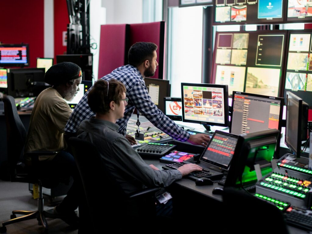 Broadcast sales team managing multi-screen media operations in a control room, highlighting the need for centralized CTV infrastructure and unified media buying