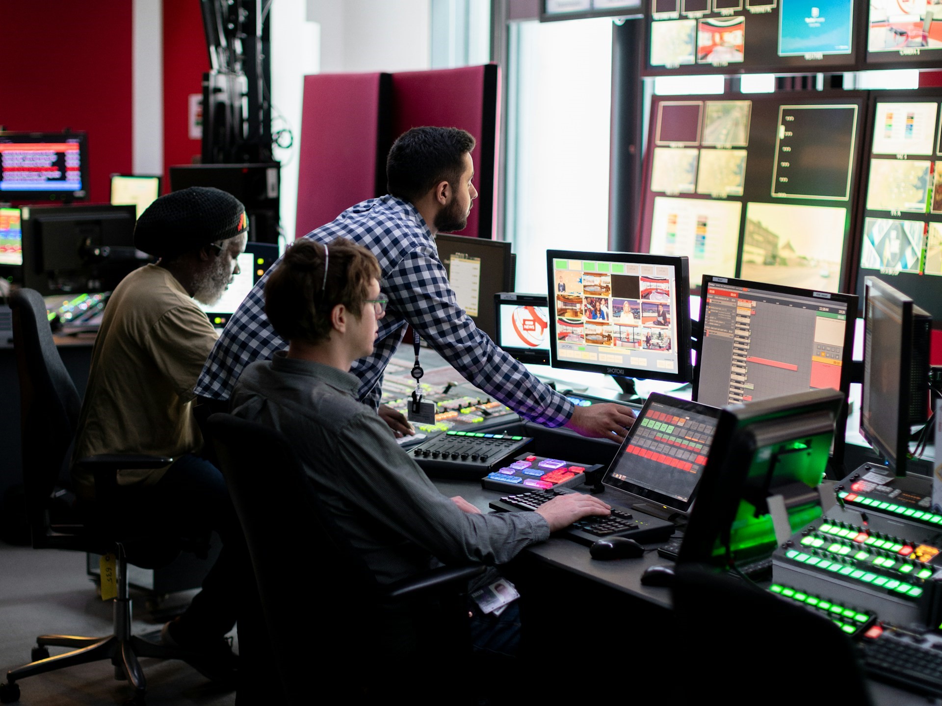 Broadcast sales team managing multi-screen media operations in a control room, highlighting the need for centralized CTV infrastructure and unified media buying